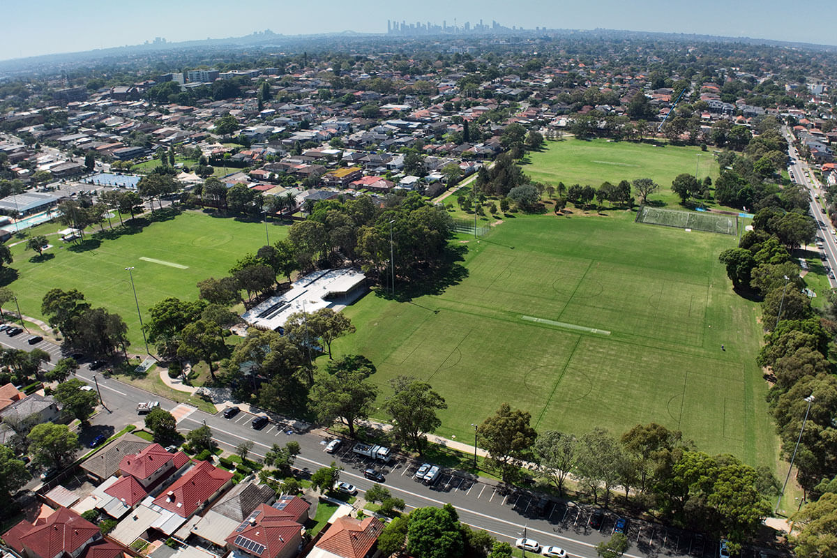 Aerial view over Henley Park of grassy playing fields with trees surrounding the parks.